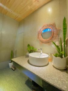 a bathroom with a sink and a mirror on the wall at Buon'S garden in Buôn Kao