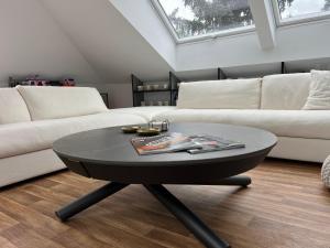 a living room with a black coffee table and a couch at Modern Attic Loft in Weisenheim am Sand
