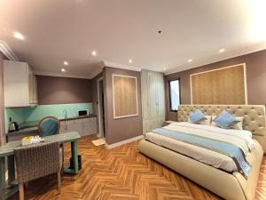 a bedroom with a bed and a table and a kitchen at Khách Sạn PG Boutique in Vung Tau
