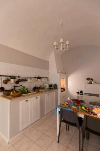 a kitchen with white cabinets and a blue table at Nel Blu Dipinto di Blu - Casa Anemone in Polignano a Mare
