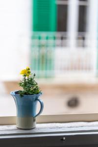 a yellow flower in a blue vase sitting on a window sill at Nel Blu Dipinto di Blu - Casa Anemone in Polignano a Mare