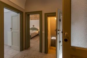 a hallway with two doors and a bed in a room at Nel Blu Dipinto di Blu - Casa Anemone in Polignano a Mare +19 photos