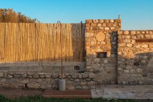 a stone wall next to a wooden fence at IoMi Terra & Mare in Eleonas