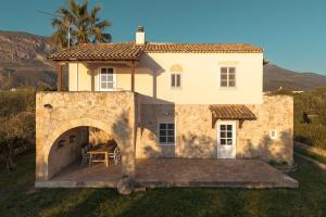 a house with a patio in front of it at IoMi Terra & Mare in Eleonas