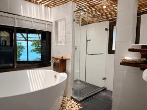 a bathroom with a tub and a glass shower at Ting Rai Bay Resort in Ko Jum +57 photos