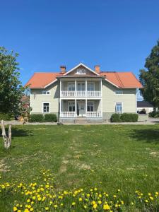 a house with a large yard with yellow flowers at 3A Centralt Boende i Dala-Floda! in Djuras