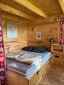 a wooden cabin with a bed in a room at Camping Osenbach in Osenbach