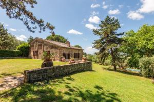 an old stone house with a stone wall in a yard at Agriturismo Montechiaro in Siena