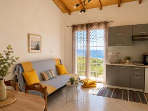 a living room with a couch and a table and a kitchen at Terra Saronia in Metamórfosis