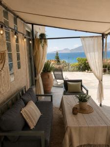 a patio with a couch and a table with a view of the ocean at Terra Saronia in Metamórfosis