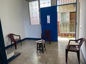 two chairs and a table in a room with a blue door at Mio y tuyo in Flores