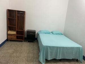 a small bedroom with a bed and a cabinet at Mio y tuyo in Flores