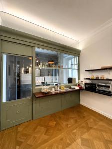 a kitchen with green cabinets and a large window at Relais Donna Lucrezia in Rome