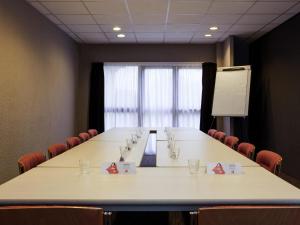 a conference room with a long table and chairs at Ibis Provins in Provins