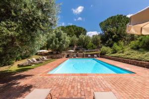 a swimming pool in a yard with chairs and trees at Agriturismo Montechiaro in Siena