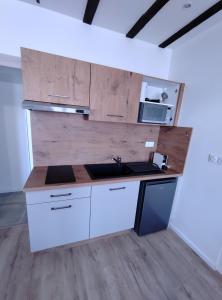 a kitchen with a counter with a sink and a microwave at OLOO Habitat - Le 3 in Lure +13 photos