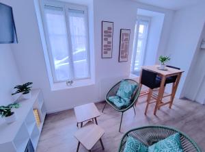 a living room with a table and chairs and a desk at OLOO Habitat - Le 3 in Lure
