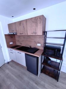 a small kitchen with a sink and a microwave at OLOO Habitat - Le 3 in Lure