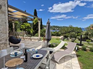 a patio with a table and chairs and an umbrella at Charming Sea View "Villa Divine" in Lopud