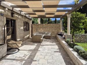 a patio with a couch under a pergola at Charming Sea View "Villa Divine" in Lopud +29 photos
