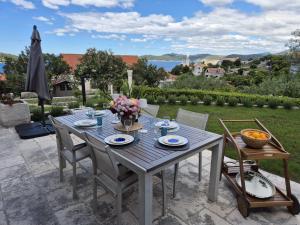 a blue table with chairs and flowers on a patio at Charming Sea View "Villa Divine" in Lopud