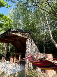 a hammock sitting under a wooden bridge in a park at Domki Brzozowy Zakątek in Sochy