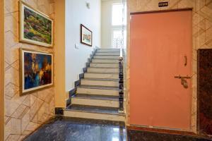 a staircase in a house with a orange door at Fabhotel Grant Heights - Nr Biju Patnaik International Airport in Bhubaneshwar