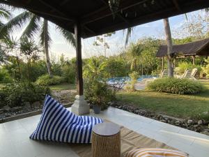 a blue and white pillow sitting on a patio at Romantic Tropical Retreat with Sunset & Rice Field Views in Kuah