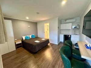 a living room with a couch and a kitchen at Willows Motel in Goulburn
