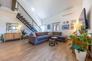 a living room with a couch and a staircase at NIMA Cozy Stay Mlini in Mlini