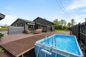 a house with a swimming pool on a wooden deck at Beach cottage in Søgne in Kristiansand