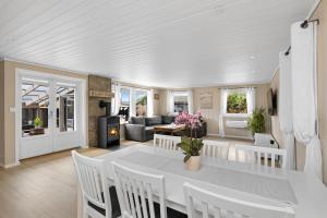 a dining room and living room with a white table and chairs at Beach cottage in Søgne in Kristiansand