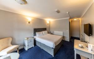 a small hotel room with a bed and a desk at Littleover Lodge Hotel in Derby