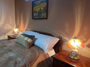 a bedroom with a bed and a lamp on a table at Comfortable with Private Garage and Excellent Location Rb in Riobamba