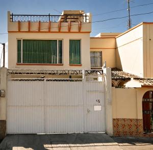 a house with white garage doors in front of it at Comfortable with Private Garage and Excellent Location Rb in Riobamba
