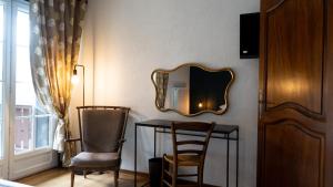 a room with a table and two chairs and a mirror at Auberge Du Roselet in Duingt