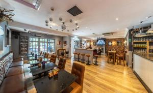 a restaurant with tables and chairs and a bar at Littleover Lodge Hotel in Derby