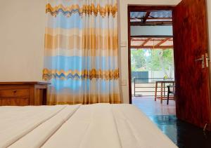 a bedroom with a bed and a curtain and a door at Aqua Bliss Resort & Villa Bentota in Bentota +77 photos
