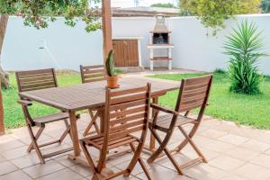 a wooden table and chairs with a bird sitting on it at Calma house Zahora in Zahora