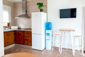 a kitchen with a white refrigerator and a table at Calma house Zahora in Zahora +7 photos
