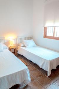two beds in a room with two windows at Calma house Zahora in Zahora