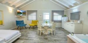 a bedroom with a table and chairs and a kitchen at בקתות לוטן דלתון - 4 בקתות עם ג'קוזי פרטי ו-2 בריכות משותפות in Shahar