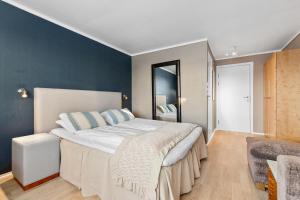 a bedroom with a large bed and a blue wall at Gomobu Fjellstue in Ron +64 photos