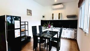 a dining room with a black table and chairs at La Casa Bangtao Resort in Ban Thalat Choeng Thale
