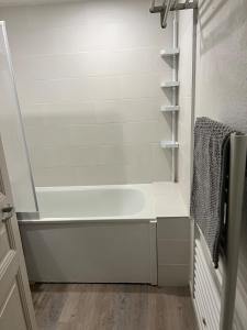 a white bath tub in a bathroom with a wooden floor at L'Atelier 37 - Centre Tours in Tours +9 photos