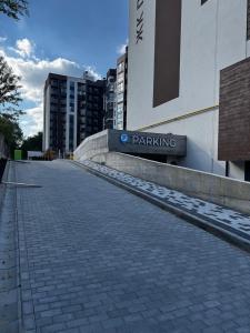 an empty street in front of a building with a parking sign at Перлина Люкс in Khmelnytskyi