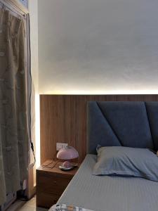 a bed with a blue headboard and a pink lamp at Stay Royal Imperial in Jammu