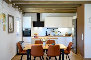 a kitchen with a wooden table and chairs at NIMA Cozy Stay Mlini in Mlini