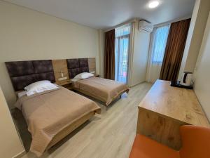 a hotel room with two beds and a desk at Hotel Royal Georgia 2 in Batumi +37 photos