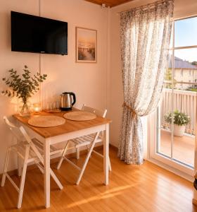 a dining room with a table and a window at Saulės Namai in Palanga